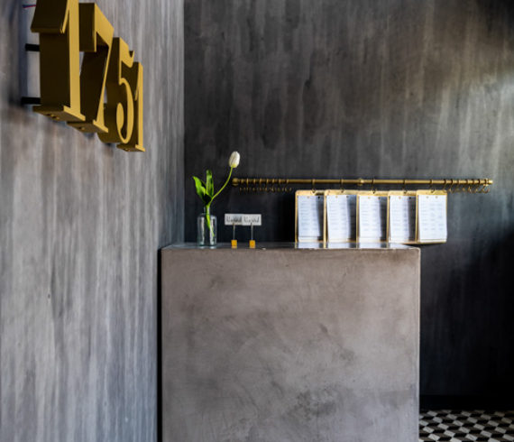 Restaurant entry with hand-painted wallcovering by Porter Teleo. plaster hostess stand and brass menus. Photographed by Michael Hunter.